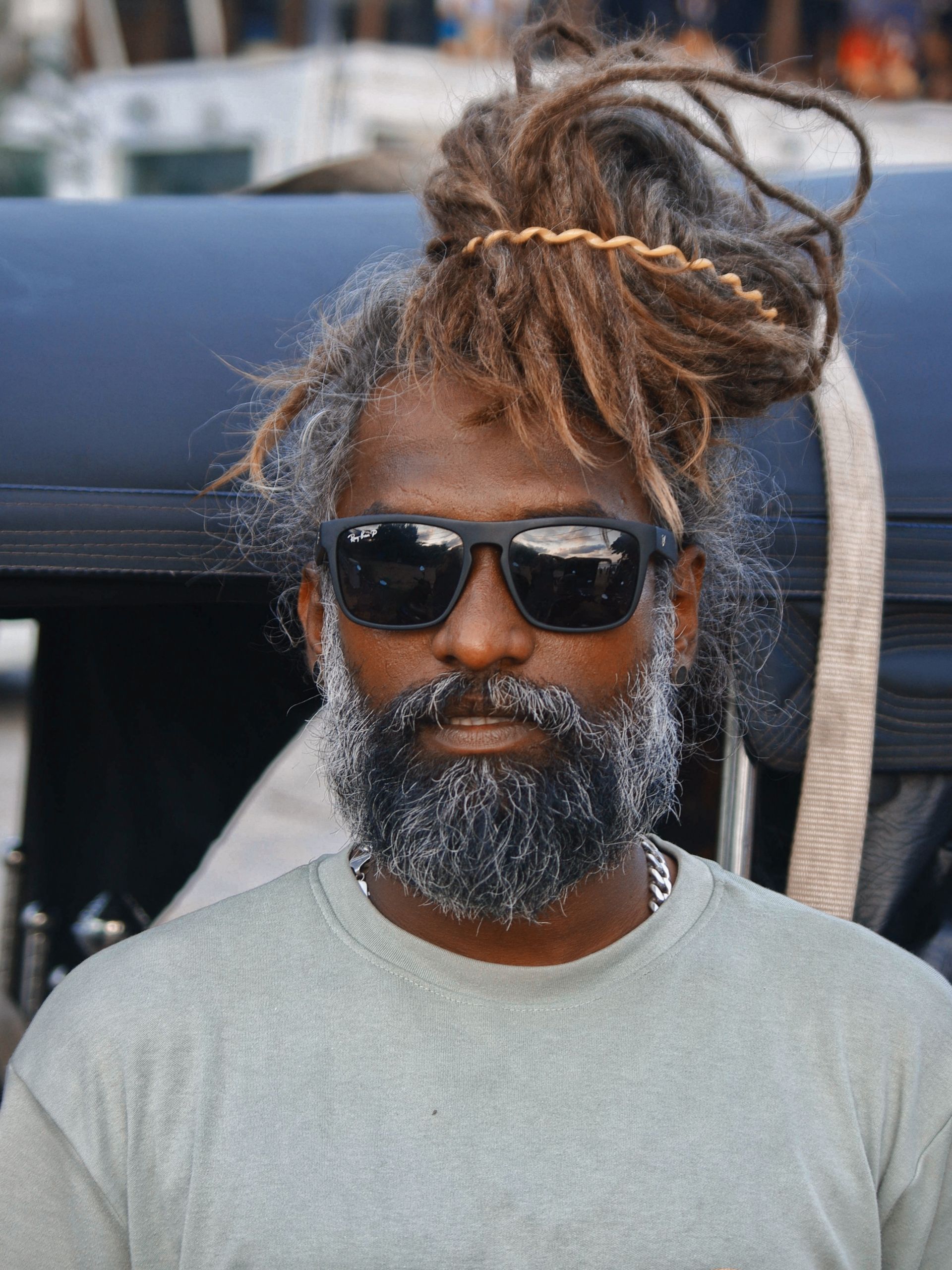 A stylish man with dreadlocks and sunglasses captured outdoors in Sri Lanka.